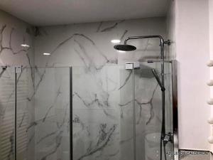 VISTA DE PERFIL SUPERIOR DE MAMPARA Y FONDO DE DUCHA AZULEJADO CON PORCELANICO BLANCO IMITACION MARMOL "CALACATA" PULIDO Y RECTIFICADO 60x120 Cm.
