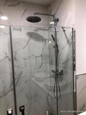 VISTA DE PERFIL SUPERIOR DE MAMPARA Y FONDO DE DUCHA AZULEJADO CON PORCELANICO BLANCO IMITACION MARMOL "CALACATA" PULIDO Y RECTIFICADO 60x120 Cm.