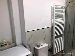 VISTA DE RADIADOR TOALLERO BLANCO Y ZOCALO IMITACION MARMOL  CON LISTELO DE CRISTAL EFECTO ESPEJO Y PINTURA ANTIMOHO BLANCA  HASTA EL TECHO