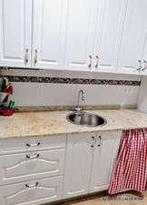 VISTA DE COCINA REFORMADA . MUEBLES ALTOS Y BAJOS ESTILO BLANCO  RUSTICO Y ENCIMERA EN GRANITO NACIONAL